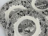 four black and white plates with animals on them sitting on a table