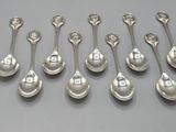 six cuillères en argent sont alignées sur une table