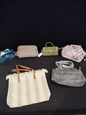 several purses are lined up on a table with a black background
