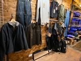 a picture of a clothing store with clothes hanging on the wall