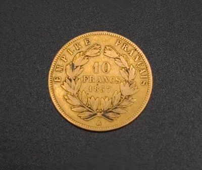a close up of a gold coin on a black surface