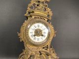 a gold clock that is sitting on a table