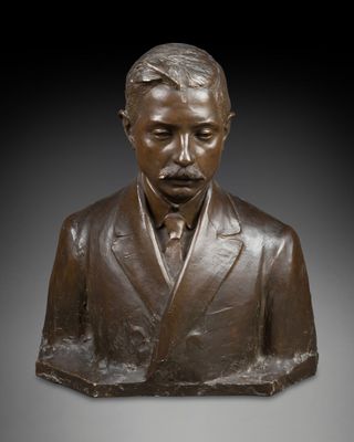 un buste en bronze représentant un homme en costume-cravate