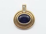 a close up of a blue stone and diamond pendant on a white surface