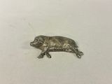 a small metal animal figurine sitting on a white surface