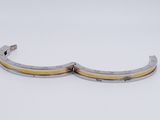 pair of silver and yellow metal cuff bracelets on white surface