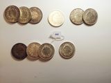 several different coins are arranged in a row on a table