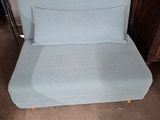 a blue couch that is sitting in the middle of a room
