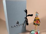 a small figurine of a woman standing next to a box