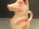 a pink pig shaped vase sitting on a table