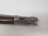 a close up of a gun on a table with a white background