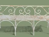 a white bench that is sitting on a green surface