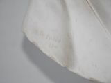 a white bag hanging from a hook on a wall