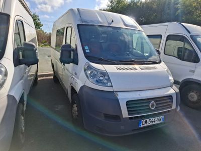 several white vans are parked in a parking lot with trees in the background