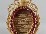 an image of a close up of a necklace with a clock on it