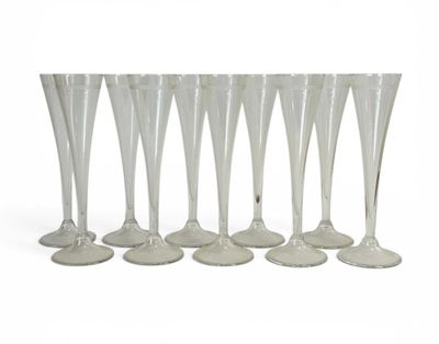 six verres à vin transparents alignés sur une surface blanche