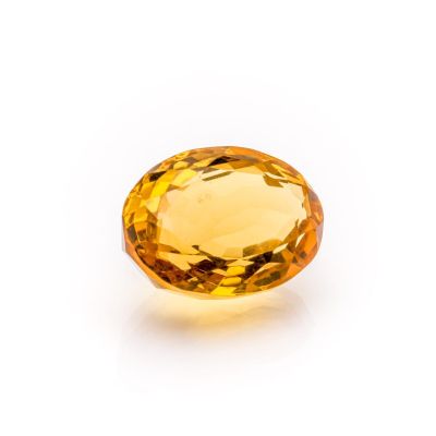 a yellow sapphire stone on a white background