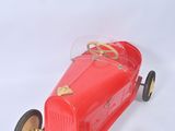 a red toy car that is sitting on a white surface