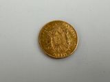 a close up of a gold coin on a white surface