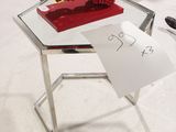 une petite table sur laquelle se trouve un vase rouge