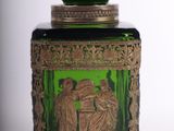 a green glass jar with a picture of a man and a woman on it