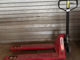 une palette rouge posée devant une porte de garage