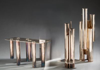 une table sur laquelle sont posés plusieurs vases en verre