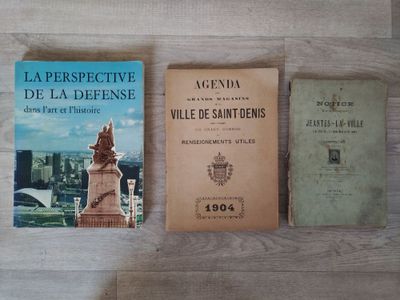 trois livres posés les uns à côté des autres sur une table, posée elle-même sur un plancher en bois