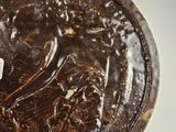 a chocolate cake with icing on it sitting on a plate