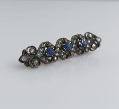 un gros plan sur une paire de boucles d'oreilles en saphir bleu et diamants