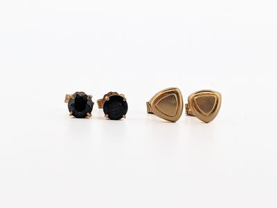 a pair of black diamond stud earrings on a white surface