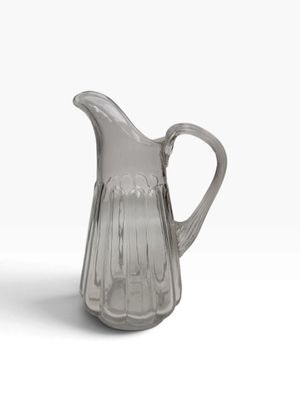 une photo d'un pichet en verre transparent posé sur une surface blanche