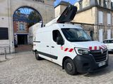 une camionnette blanche avec une bande rouge garée devant un immeuble