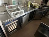 stainless steel counter top in a commercial kitchen with a wine cooler and dishwasher