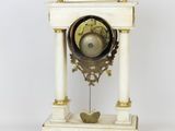 a white and gold clock sitting on a white table