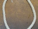 un gros plan d'un collier de perles blanches posé sur une table