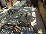 many chairs and tables on the patio under a pergol roof