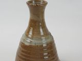 a small brown vase sitting on a white surface