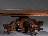 une table en bois dont le plateau est orné de sculptures