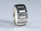 a close up of a silver ring with diamonds on it