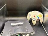 une console de jeux vidéo et une manette de jeu dans une boîte en métal