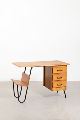 un bureau en bois muni de deux tiroirs, avec une chaise placée devant