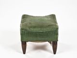 un repose-pieds rembourré avec une assise recouverte de velours vert