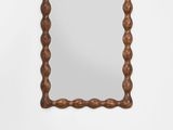 a wooden mirror with a rope frame hanging on the wall