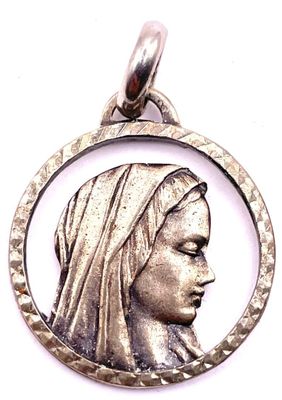 un gros plan d'un pendentif en argent représentant le visage d'une femme dans un cercle