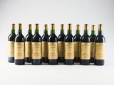 six bottles of wine lined up in a row on a white surface