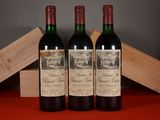 three bottles of red wine sitting on a table next to a wooden box