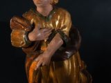 an image of a statue of a woman sitting on a black surface