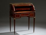 a small writing desk with two drawers and gold trimmings