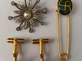 two gold and green brooches, a pin, and a broocher